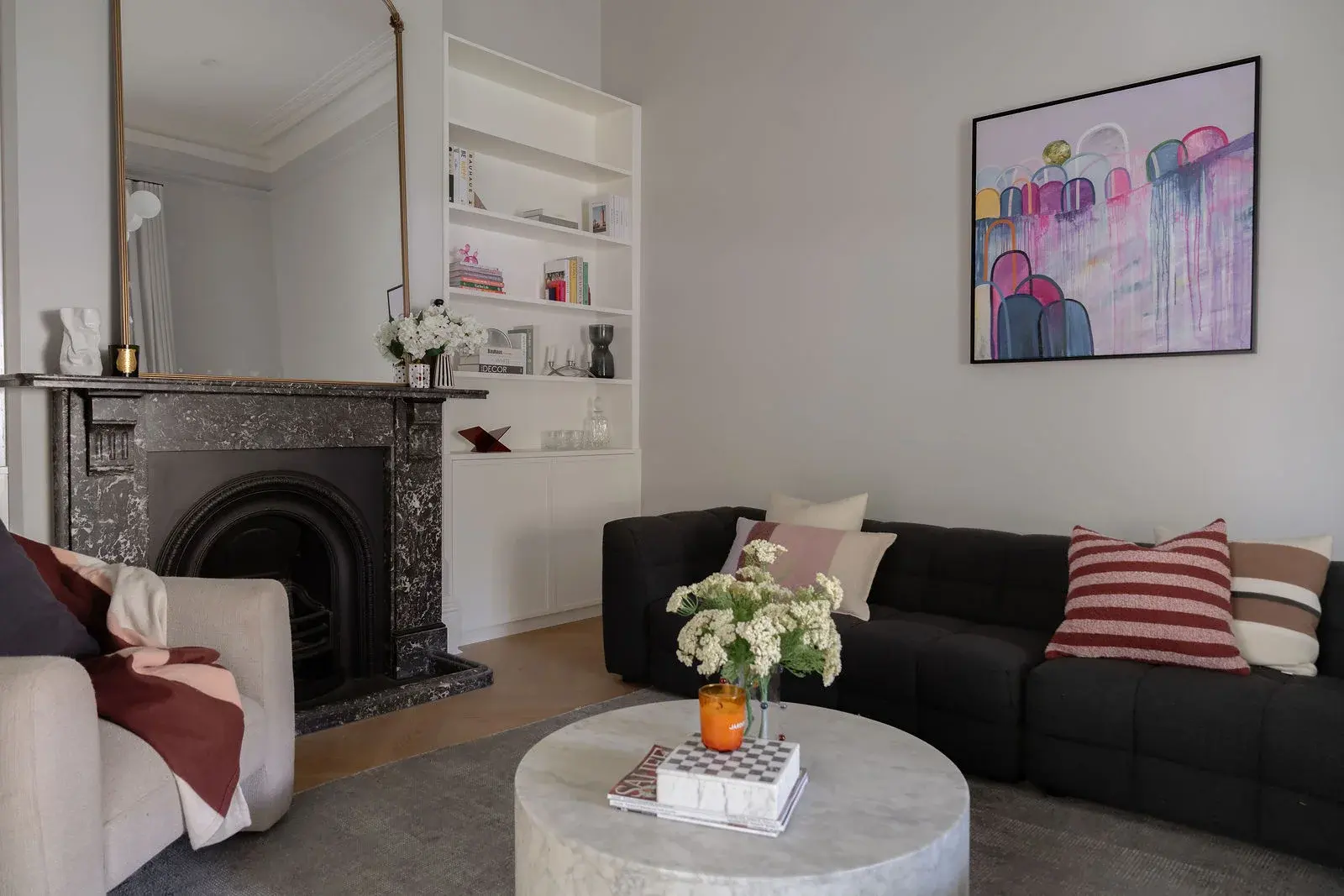 Formal lounge with black marble fireplace and brass mirror