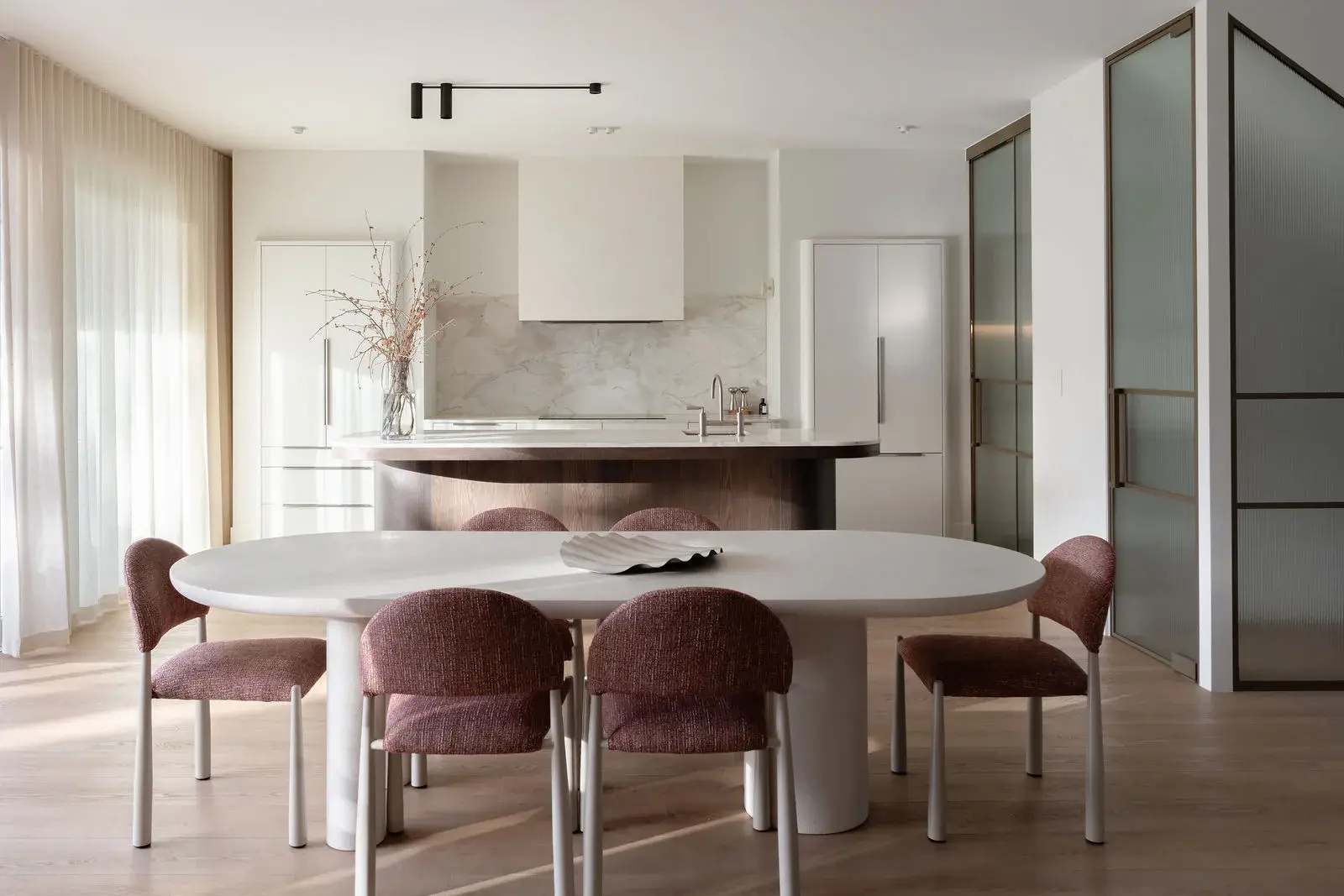 Open-plan dining before the curved Artisan kitchen island